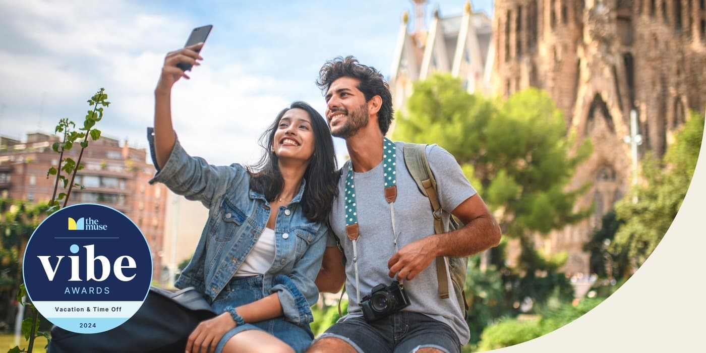 A couple smiling as they take a scenic selfie,