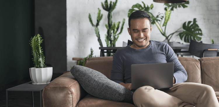 person sitting on a couch with a laptop