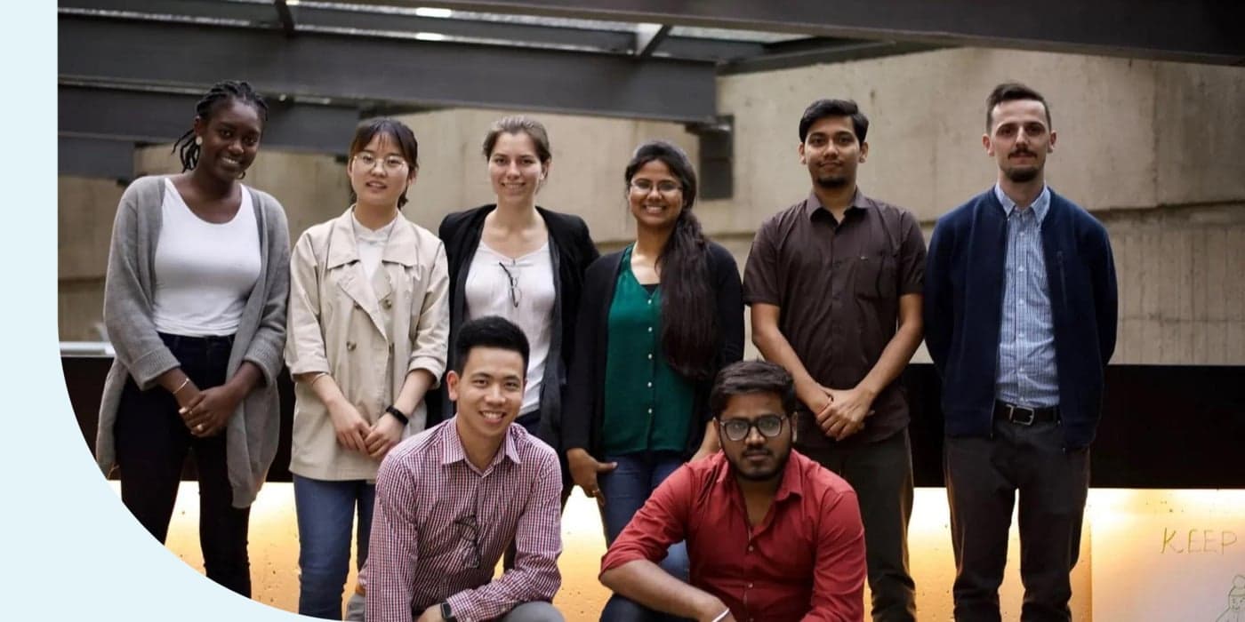 A group of people facing the camera. Two people are crouched in the bottom row; six people are standing behind them.