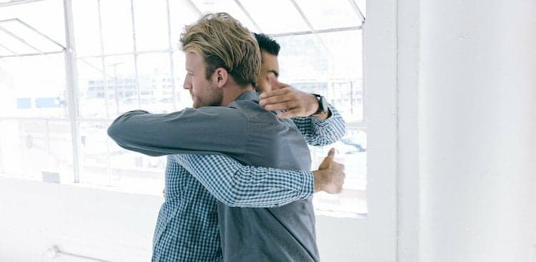 people hugging in office